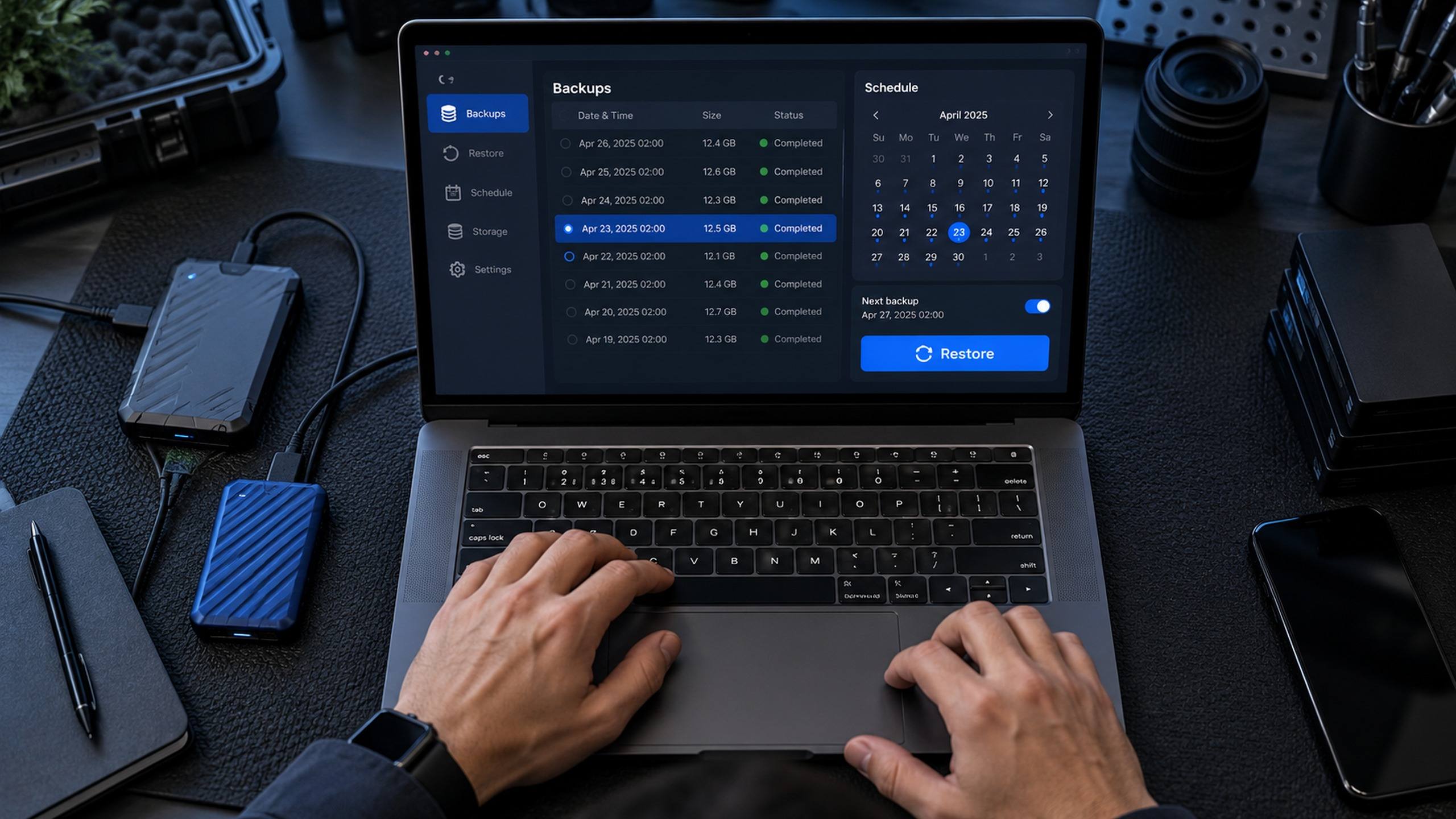 Notebook com painel de backups, histórico de cópias e botão de restauração, ao lado de um disco externo
